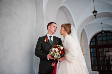 İki muhteşem düğün yürüyor ve eski yapı yanında poz