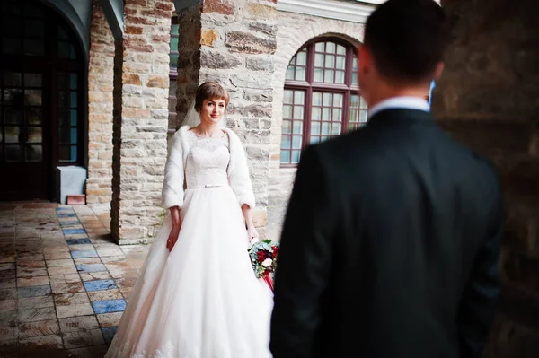 Casal de casamento fabuloso andando e posando ao lado da construção antiga — Fotografia de Stock