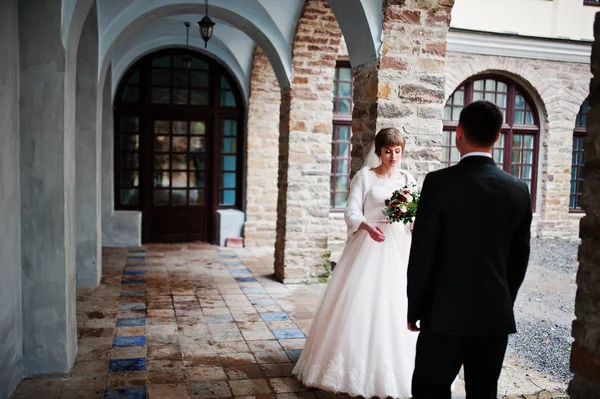 Skvělé svatební pár chůzi a pózuje vedle staré sestavení — Stock fotografie