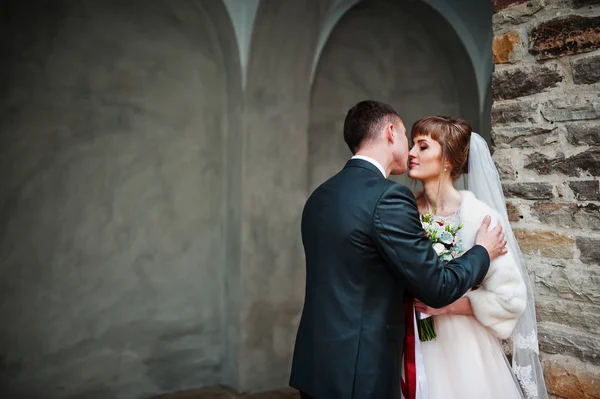 Casal de casamento fabuloso andando e posando ao lado da construção antiga — Fotografia de Stock