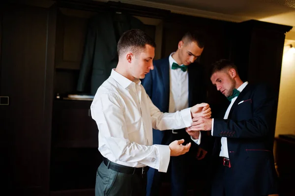 Groomsmen βοηθώντας γαμπρός να ντύνονται και να ετοιμαστείτε για τον weddin — Φωτογραφία Αρχείου