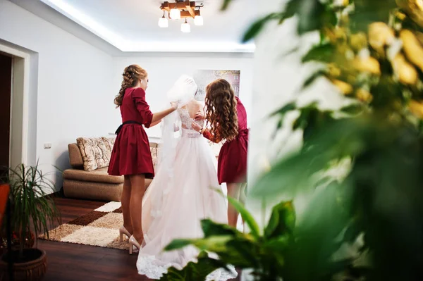Dama de honra ajudando noiva para amarrar um arco em um vestido de noiva . — Fotografia de Stock