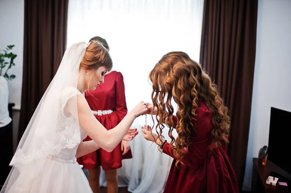 Yakışıklı nedime gelin bir bilezik takmayı yardım.