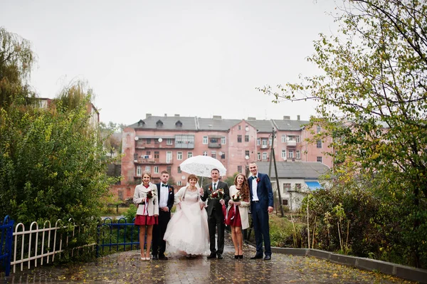 Ζευγάρι γάμος και groomsmen με παράνυμφοι περπάτημα σε ένα βροχερό — Φωτογραφία Αρχείου