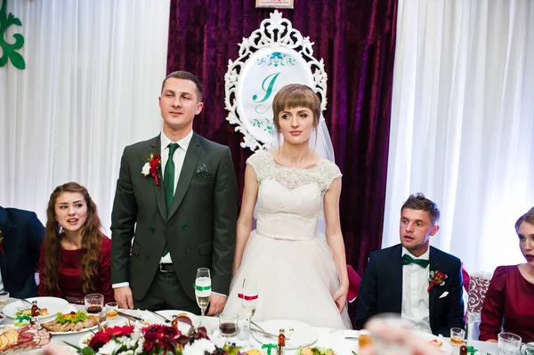 Awesome bruidspaar permanent aan hun tafel met bruidsmeisjes — Stockfoto