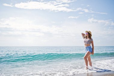 Deniz bir sahilde rahatlatıcı, kot sho üzerinde giyen güzel model