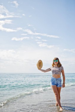 Deniz bir sahilde rahatlatıcı, kot sho üzerinde giyen güzel model