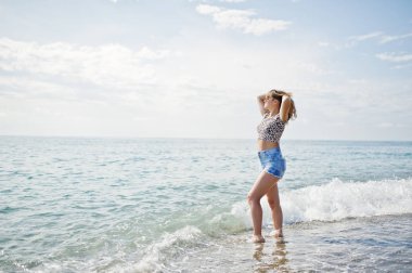 Deniz bir sahilde rahatlatıcı, kot sho üzerinde giyen güzel model