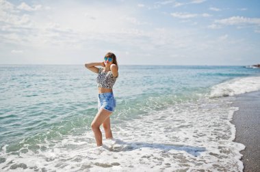 Deniz bir sahilde rahatlatıcı, kot sho üzerinde giyen güzel model