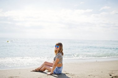 Deniz bir sahilde rahatlatıcı, kot sho üzerinde giyen güzel model