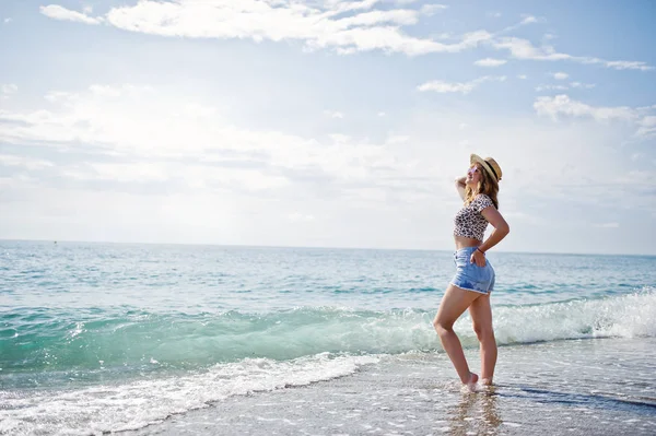 Hermosa modelo relajante en una playa de mar, vistiendo en jeans sho —  Fotos de Stock