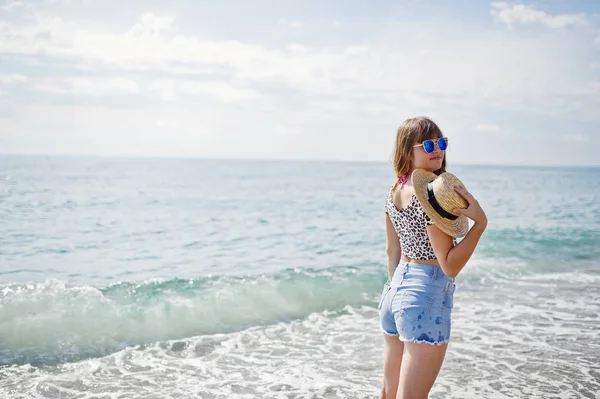Hermosa modelo relajante en una playa de mar, vistiendo en jeans sho —  Fotos de Stock