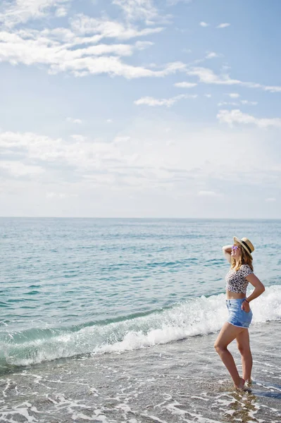 Deniz bir sahilde rahatlatıcı, kot sho üzerinde giyen güzel model