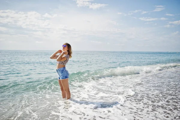 Deniz bir sahilde rahatlatıcı, kot sho üzerinde giyen güzel model