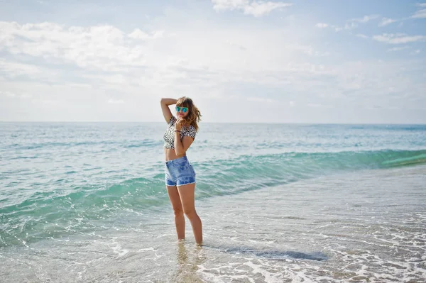 Deniz bir sahilde rahatlatıcı, kot sho üzerinde giyen güzel model