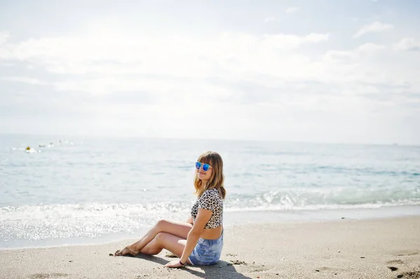 Το όμορφο μοντέλο χαλαρώνοντας σε μια παραλία της θάλασσας, φορώντας την τζιν sho — Φωτογραφία Αρχείου