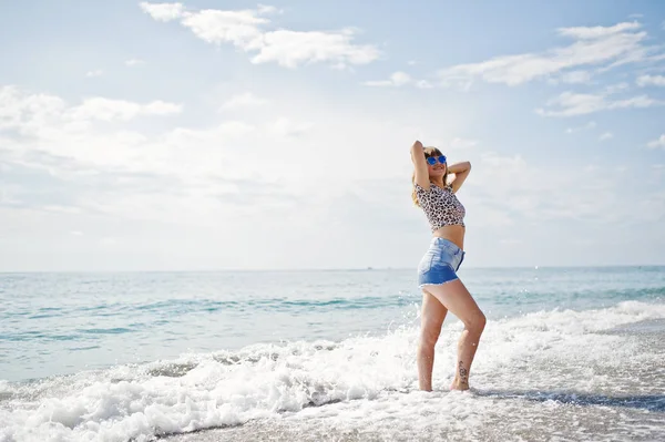 Deniz bir sahilde rahatlatıcı, kot sho üzerinde giyen güzel model