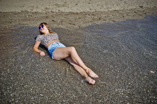 Gyönyörű modell, pihentető a strandon a tenger, a sho farmert visel — Stock Fotó