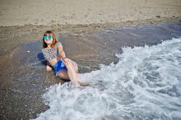 Hermosa modelo relajante en una playa de mar, vistiendo en jeans sho —  Fotos de Stock