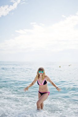 Güzel model rahatlatıcı bir plajda bir mayo giymiş.