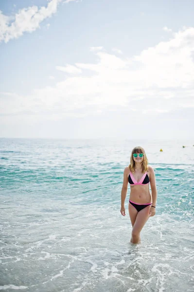 Gyönyörű modell pihentető a strandon öltözött egy fürdőruha. — Stock Fotó