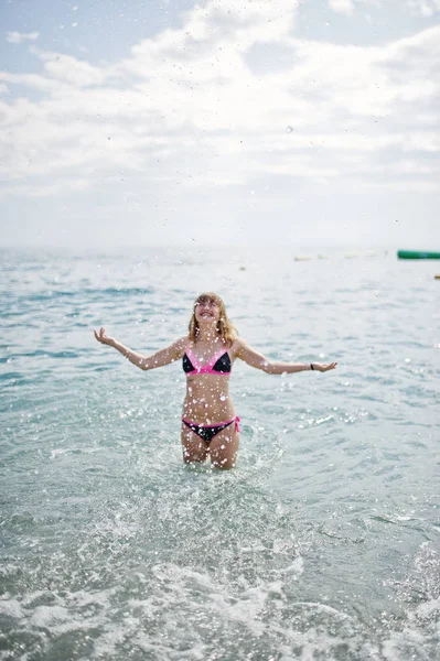 Hermosa modelo relajante en una playa vestida con un traje de baño . — Foto de Stock