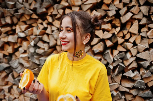 Genç kız parlak makyajlı, sarı gömlek giymek tutun 