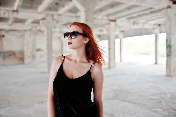 Chica de pelo rojo con estilo en gafas de sol usan en negro, contra aba — Foto de Stock