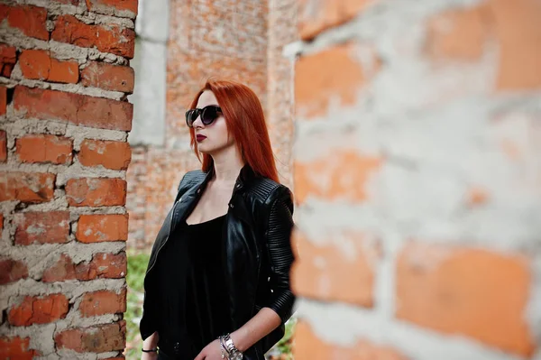 Menina de cabelo vermelho elegante em óculos de sol desgaste em preto, contra aba — Fotografia de Stock