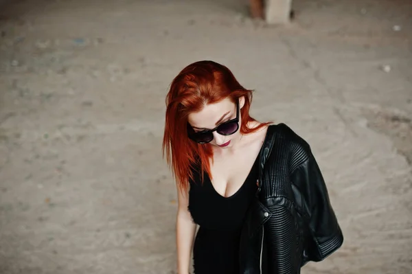 Рыжеволосая стильная девушка в солнечных очках одевается в черное, против Абы — стоковое фото