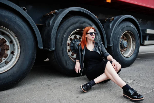 Рыжие волосы стильная девушка носить в черном, сидя против большого tru — стоковое фото