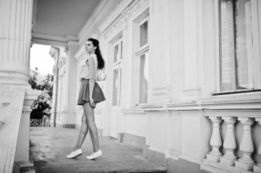 Kıvırcık şık kız kot etek giymek, poz yakınındaki o bluz