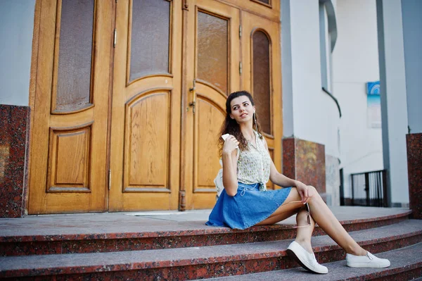 Curly elegante menina desgaste na saia jeans azul, blusa e listenin — Fotografia de Stock