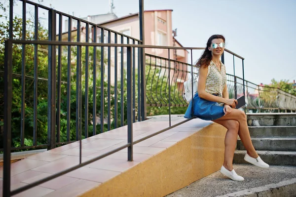 Lockiges stylisches Mädchen trägt blauen Jeansrock, Bluse mit Tablet — Stockfoto