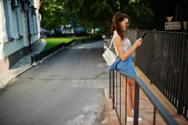 Kıvırcık şık kız giymek kot etek, bluz tablet ile 