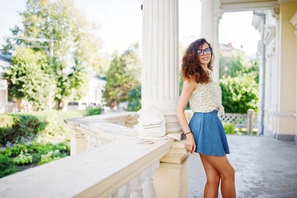 Lockiges stylisches Mädchen trägt blauen Jeansrock, Bluse und Brille — Stockfoto