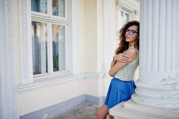 Curly elegante menina desgaste na saia jeans azul, blusa e óculos — Fotografia de Stock