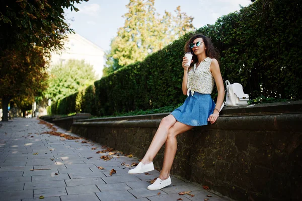 Lockigt snygg tjej slitage på blå jeans kjol, blus och glasögon — Stockfoto