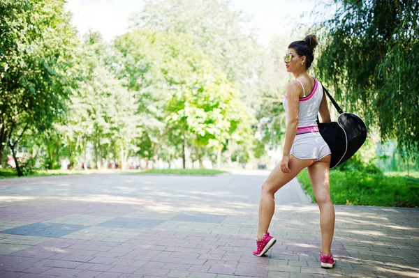 Спортивная девушка носить на белых шортах и рубашку со спортивной сумкой ходьба — стоковое фото