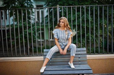 Muhteşem genç çekici modelini çizgili genel oturan bir 