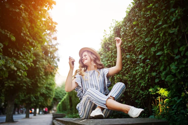 Porträtt av en fantastisk ung kvinna i randig övergripande sitter i — Stockfoto