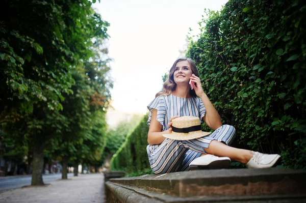 Çizgili genel oturan bir şaşırtıcı genç modeli portresi