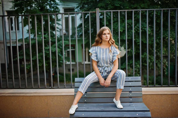 Muhteşem genç çekici modelini çizgili genel oturan bir 