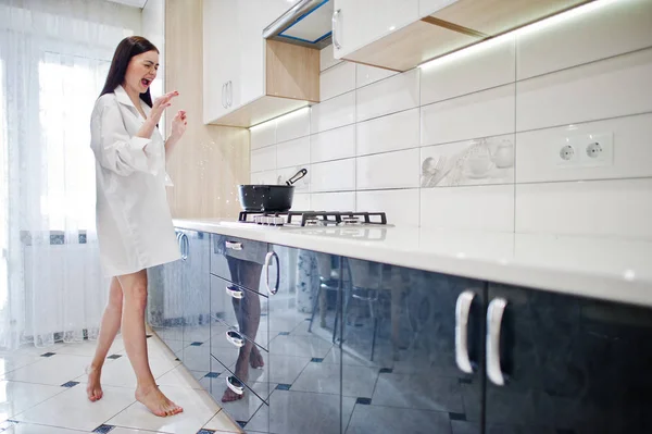 Menina morena, desgaste na camisa e roupa interior cozinhar no branco — Fotografia de Stock