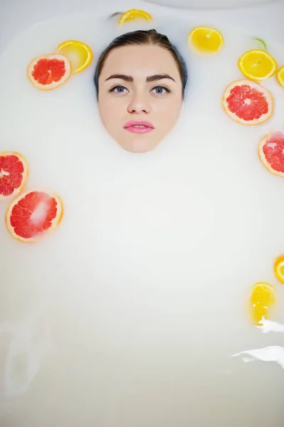 Sexy fille brune à la salle de bain avec du lait et des fruits. Jeunes b — Photo