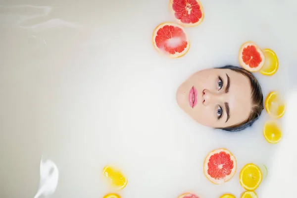 Seksowna brunetka dziewczyna w łazience z mleka i owoców. B młodzież — Zdjęcie stockowe