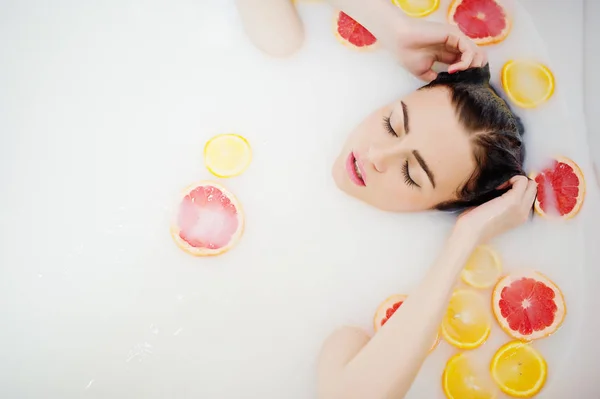 Sexy fille brune à la salle de bain avec du lait et des fruits. Jeunes b — Photo