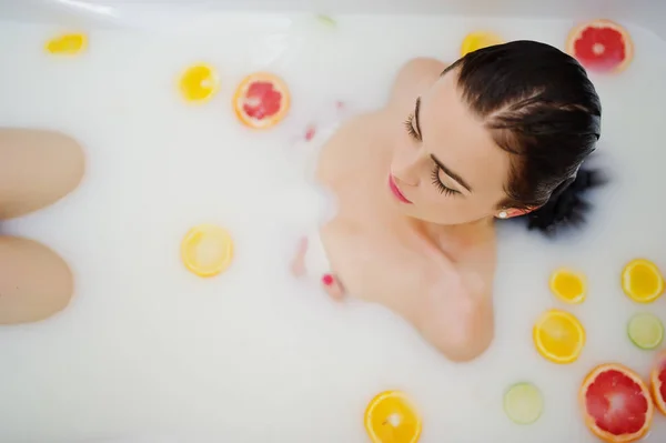 Sexy fille brune à la salle de bain avec du lait et des fruits. Jeunes b — Photo