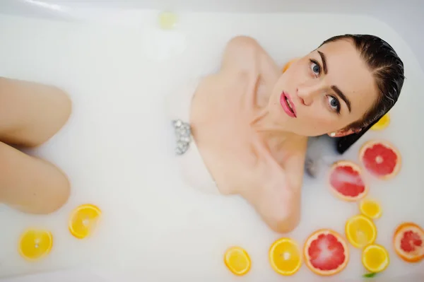 Sexy fille brune à la salle de bain avec du lait et des fruits. Jeunes b — Photo