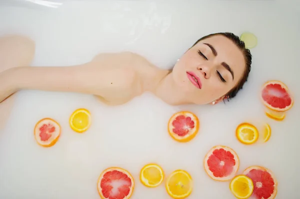Sexy brunette meisje op de badkamer met melk en fruit. Jeugd b — Stockfoto